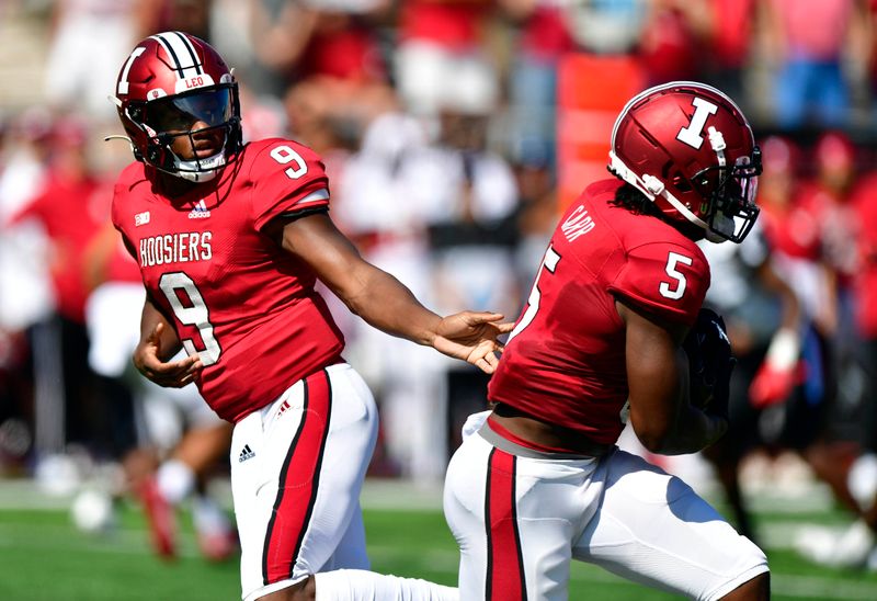 Sep 18, 2021; Bloomington, Indiana, USA; Indiana Hoosiers quarterback Michael Penix Jr. (9) hands the ball off to Indiana Hoosiers running back Stephen Carr (5) during the first quarter against the Cincinnati Bearcats  at Memorial Stadium. Mandatory Credit: Marc Lebryk-USA TODAY Sports