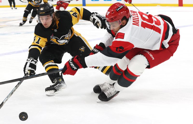 Dec 30, 2025; Pittsburgh, Pennsylvania, USA; Pittsburgh Penguins right wing Ville Koivunen (41) and Carolina Hurricanes defenseman K'Andre Miller (19) chase a loose puck during the first period at PPG Paints Arena. Mandatory Credit: Charles LeClaire-Imagn Images
