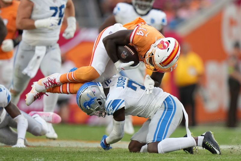 Tampa Bay Buccaneers wide receiver Chris Godwin (14) gets tackled by Detroit Lions safety Kerby Joseph (31) during an NFL football game, Sunday, Oct. 15 2023, in Tampa, Fla. (AP Photo/Peter Joneleit)