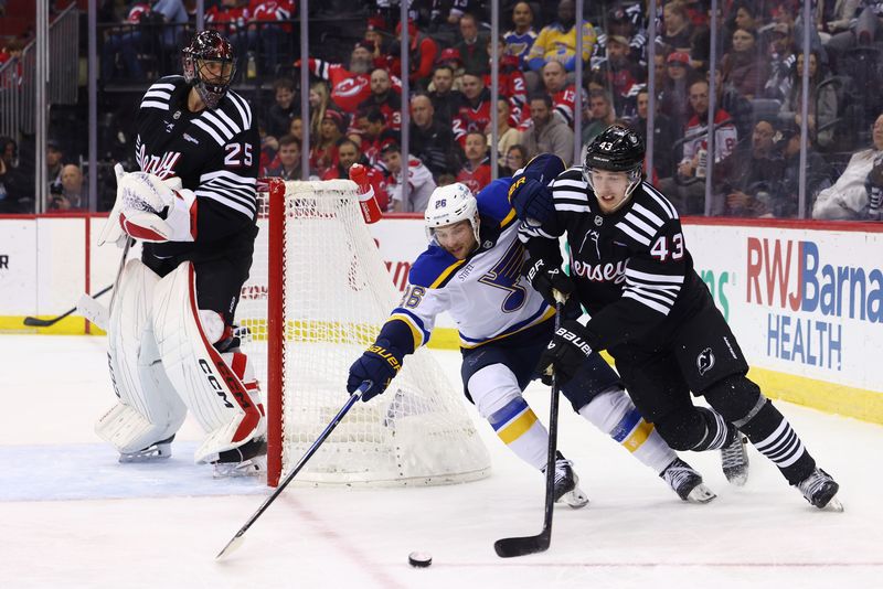 Nov 27, 2024; Newark, New Jersey, USA; New Jersey Devils defenseman Luke Hughes (43) and St. Louis Blues left wing Nathan Walker (26) battle for the puck during the third period at Prudential Center. Mandatory Credit: Ed Mulholland-Imagn Images