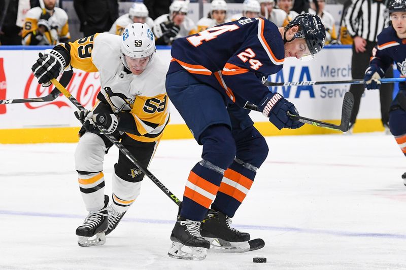 Dec 27, 2022; Elmont, New York, USA; Pittsburgh Penguins left wing Jake Guentzel (59) makes a move around New York Islanders defenseman Scott Mayfield (24) during the first period at UBS Arena. Mandatory Credit: Dennis Schneidler-USA TODAY Sports