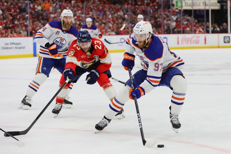 Jun 24, 2024; Sunrise, Florida, USA; Edmonton Oilers forward Connor McDavid (97) controls the puck as Florida Panthers forward Carter Verhaeghe (23) reaches to defend during the first period in game seven of the 2024 Stanley Cup Final at Amerant Bank Arena. Mandatory Credit: Sam Navarro-USA TODAY Sports
