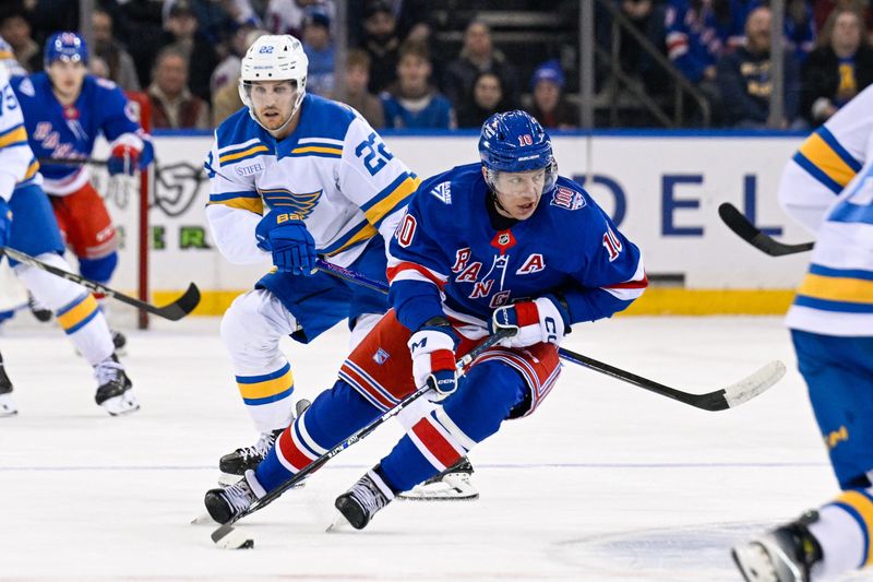 Nov 24, 2025; New York, New York, USA;  New York Rangers left wing Artemi Panarin (10) skates with the puck defended by St. Louis Blues center Pius Suter (22) during the first period at Madison Square Garden. Mandatory Credit: Dennis Schneidler-Imagn Images