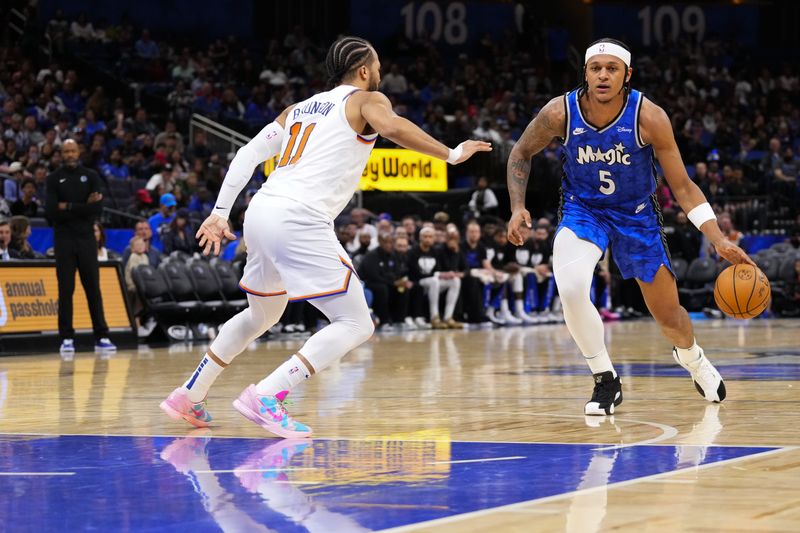 ORLANDO, FLORIDA - FEBRUARY 14: Paolo Banchero #5 of the Orlando Magic dribbles the ball up the court against Jalen Brunson #11 of the New York Knicks during the third quarter at Kia Center on February 14, 2024 in Orlando, Florida. NOTE TO USER: User expressly acknowledges and agrees that, by downloading and or using this photograph, user is consenting to the terms and conditions of the Getty Images License Agreement. (Photo by Rich Storry/Getty Images)