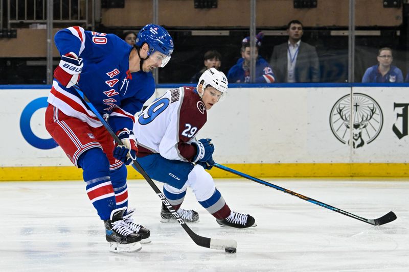 Feb 5, 2024; New York, New York, USA;  New York Rangers left wing Chris Kreider (20) skates with the puck defended by Colorado Avalanche center Nathan MacKinnon (29) during the first period at Madison Square Garden. Mandatory Credit: Dennis Schneidler-USA TODAY Sports