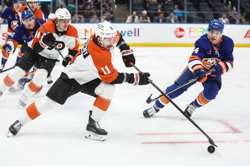 Jan 16, 2025; Elmont, New York, USA;  Philadelphia Flyers right wing Travis Konecny (11) passes the puck past New York Islanders center Jean-Gabriel Pageau (44) in the first period at UBS Arena. Mandatory Credit: Wendell Cruz-Imagn Images