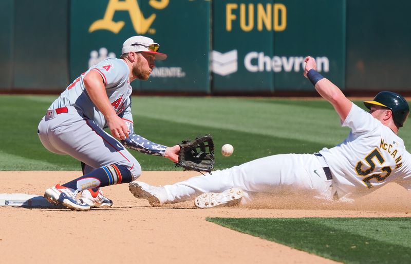 Jul 4, 2024; Oakland, California, USA; Oakland Athletics catcher Kyle McCann (52) is tagged out by Los Angeles Angels second baseman Brandon Drury (23) during the eighth inning at Oakland-Alameda County Coliseum. Mandatory Credit: Kelley L Cox-USA TODAY Sports