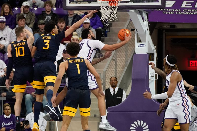 Jan 31, 2023; Fort Worth, Texas, USA; TCU Horned Frogs forward JaKobe Coles (21) scores a layup past West Virginia Mountaineers forward Tre Mitchell (3) during the second half at Ed and Rae Schollmaier Arena. Mandatory Credit: Chris Jones-USA TODAY Sports