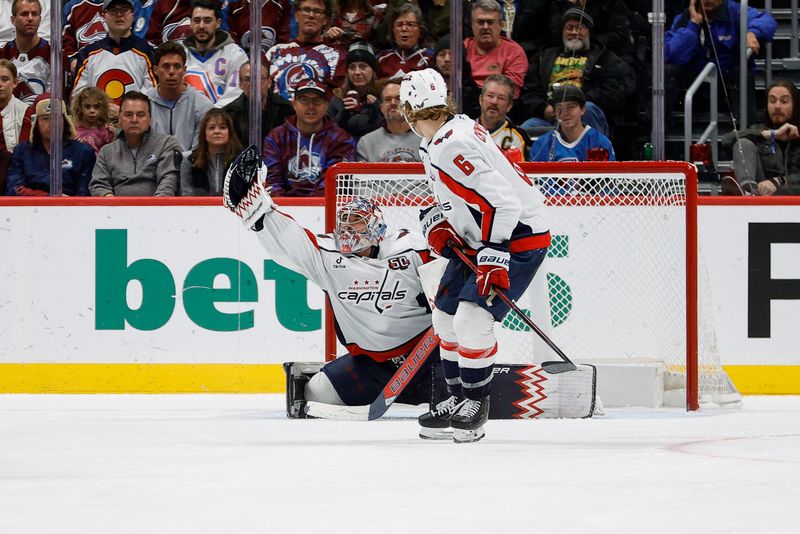 Nov 15, 2024; Denver, Colorado, USA; Washington Capitals goaltender Charlie Lindgren (79) makes a save as defenseman Jakob Chychrun (6) looks on in the third period against the Colorado Avalanche at Ball Arena. Mandatory Credit: Isaiah J. Downing-Imagn Images