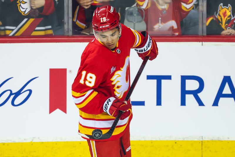 Oct 11, 2025; Calgary, Alberta, CAN; Calgary Flames defenseman Zayne Parekh (19) controls the puck during the warmup period against the St. Louis Blues at Scotiabank Saddledome. Mandatory Credit: Sergei Belski-Imagn Images