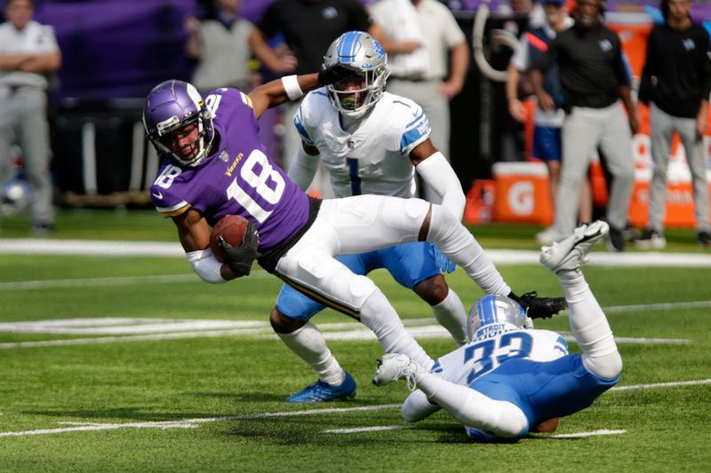 Minnesota Vikings wide receiver Justin Jefferson (18) is tackled by Detroit Lions cornerback Jeff Okudah (1) and safety JuJu Hughes (33) during the first half of an NFL football game, Sunday, Sept. 25, 2022, in Minneapolis. (AP Photo/Andy Clayton-King)