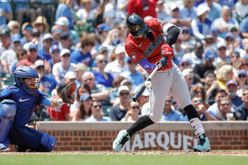 Jul 19, 2024; Chicago, Illinois, USA; Arizona Diamondbacks outfielder Lourdes Gurriel Jr. (12) singles against the Chicago Cubs during the third inning at Wrigley Field. Mandatory Credit: Kamil Krzaczynski-USA TODAY Sports