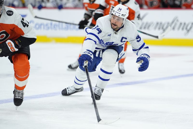Nov 1, 2025; Philadelphia, Pennsylvania, USA; Toronto Maple Leafs center Auston Matthews (34) reaches for the puck against the Philadelphia Flyers in the second period at Xfinity Mobile Arena. Mandatory Credit: Kyle Ross-Imagn Images