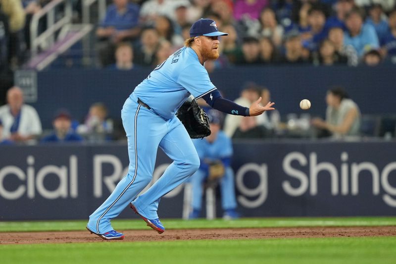 Apr 28, 2024; Toronto, Ontario, CAN; Toronto Blue Jays first baseman Justin Turner (2) throws to pitcher Kevin Gausman (not pictured) to get out Los Angeles Dodgers catcher Austin Barnes (not pictured during the third inning at Rogers Centre. Mandatory Credit: John E. Sokolowski-USA TODAY Sports
