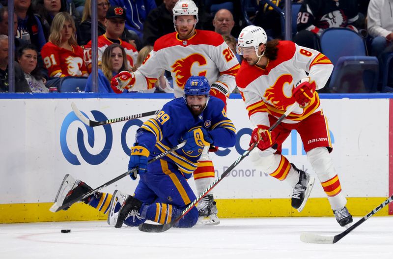 Oct 19, 2023; Buffalo, New York, USA;  Buffalo Sabres right wing Alex Tuch (89) clears the puck as Calgary Flames defenseman Chris Tanev (8) defends during the first period at KeyBank Center. Mandatory Credit: Timothy T. Ludwig-USA TODAY Sports