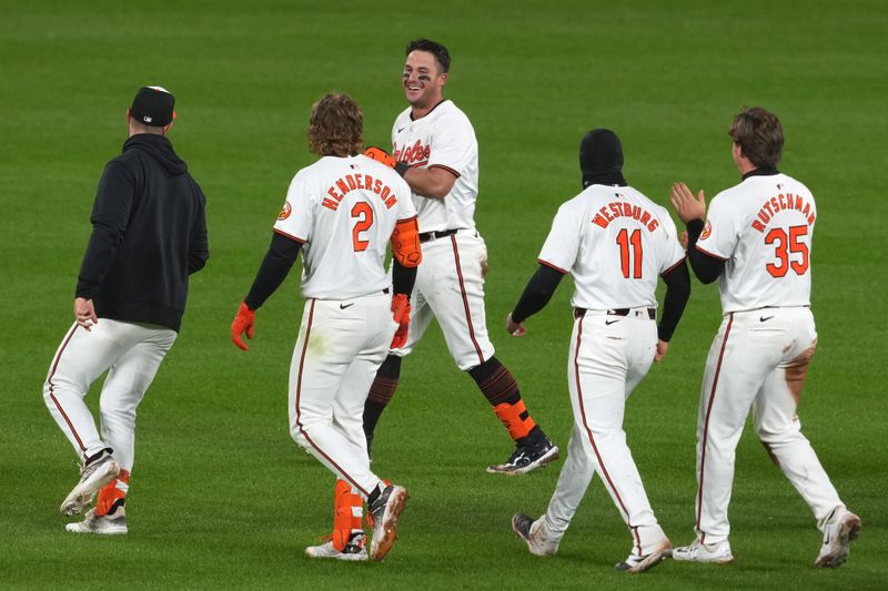 Apr 3, 2024; Baltimore, Maryland, USA; Baltimore Orioles catcher James McCann (facing) celebrates his game winning hit in the ninth inning against the Kansas City Royals at Oriole Park at Camden Yards. Mandatory Credit: Mitch Stringer-USA TODAY Sports