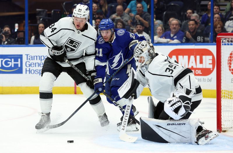 Jan 9, 2024; Tampa, Florida, USA; Tampa Bay Lightning center Brayden Point (21) skates as Los Angeles Kings right wing Arthur Kaliyev (34) defend and they look at the puck as Los Angeles Kings goaltender Cam Talbot (39) defends during the first period at Amalie Arena. Mandatory Credit: Kim Klement Neitzel-USA TODAY Sports