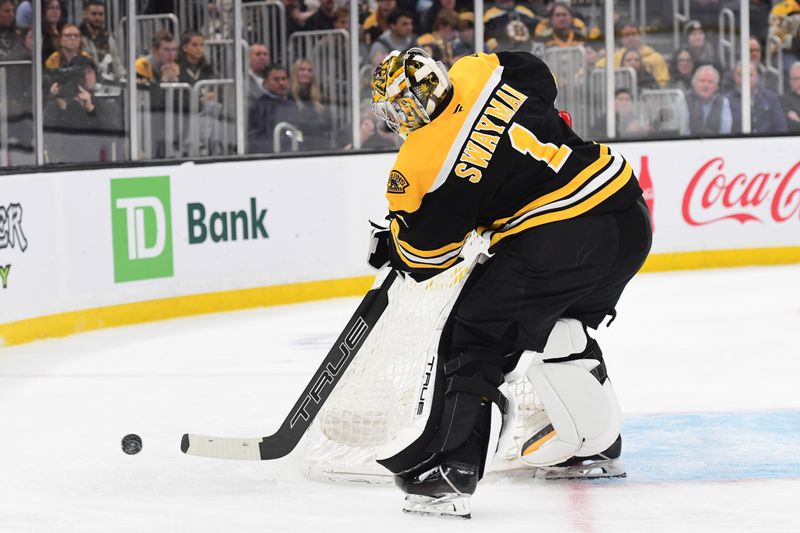 Nov 18, 2024; Boston, Massachusetts, USA;  Boston Bruins goaltender Jeremy Swayman (1) clears the puck around the goal during the second period against the Columbus Blue Jackets at TD Garden. Mandatory Credit: Bob DeChiara-Imagn Images