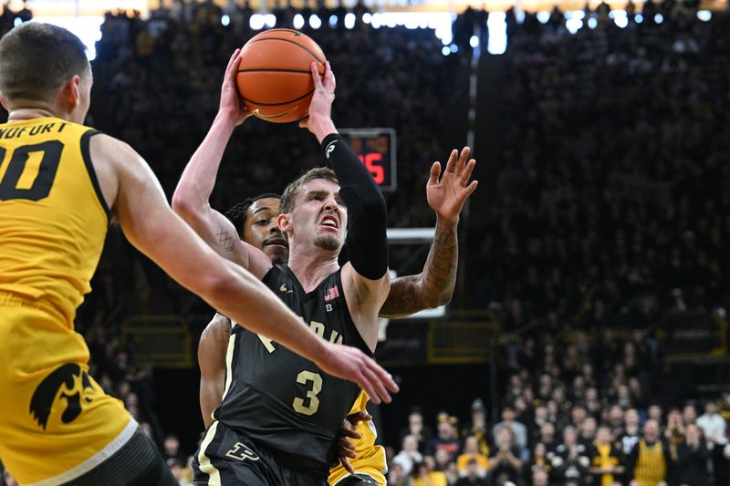 Jan 20, 2024; Iowa City, Iowa, USA; Purdue Boilermakers guard Braden Smith (3) goes to the basket as Iowa Hawkeyes forward Payton Sandfort (20) and guard Dasonte Bowen (rear) defend during the first half at Carver-Hawkeye Arena. Mandatory Credit: Jeffrey Becker-USA TODAY Sports