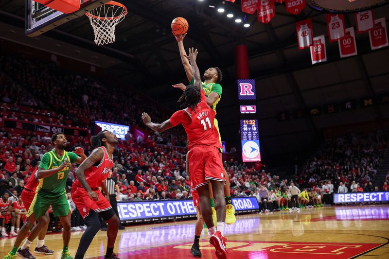 Jan 5, 2026; Piscataway, New Jersey, USA; Oregon Ducks forward Kwame Evans Jr. (10) shoots the ball as Rutgers Scarlet Knights forward Christopher Nwuli (11) defends during the first half at Jersey Mike's Arena. Mandatory Credit: Vincent Carchietta-Imagn Images