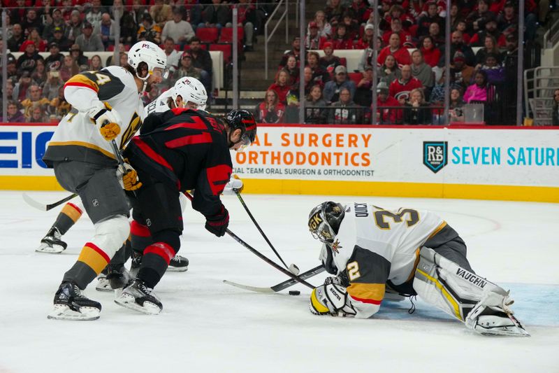 Mar 11, 2023; Raleigh, North Carolina, USA; Vegas Golden Knights goaltender Jonathan Quick (32) defenseman Nicolas Hague (14) and Carolina Hurricanes right wing Jesper Fast (71) go after the rebound during the third period at PNC Arena. Mandatory Credit: James Guillory-USA TODAY Sports