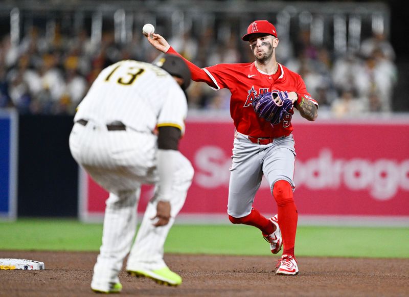May 14, 2025; San Diego, California, USA; Los Angeles Angels shortstop Zach Neto (9) throws over San Diego Padres third baseman Manny Machado (13) as he tries to turn a double play during the sixth inning at Petco Park. Mandatory Credit: Denis Poroy-Imagn Images