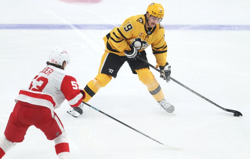 Jan 1, 2026; Pittsburgh, Pennsylvania, USA;  Pittsburgh Penguins center Connor Dewar (19) moves the puck against Detroit Red Wings defenseman Moritz Seider (53) during the second period at PPG Paints Arena. Mandatory Credit: Charles LeClaire-Imagn Images