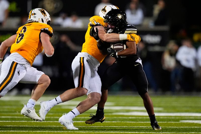 Sep 20, 2025; Boulder, Colorado, USA; Wyoming Cowboys defensive end Brayden Wilson (5) tackles Colorado Buffaloes quarterback Kaidon Salter (3) in first quarter at Folsom Field. Mandatory Credit: Ron Chenoy-Imagn Images
