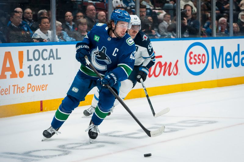 Nov 11, 2025; Vancouver, British Columbia, CAN; Vancouver Canucks defenseman Quinn Hughes (43) handles the puck against the Winnipeg Jets in the first period at Rogers Arena. Mandatory Credit: Bob Frid-Imagn Images