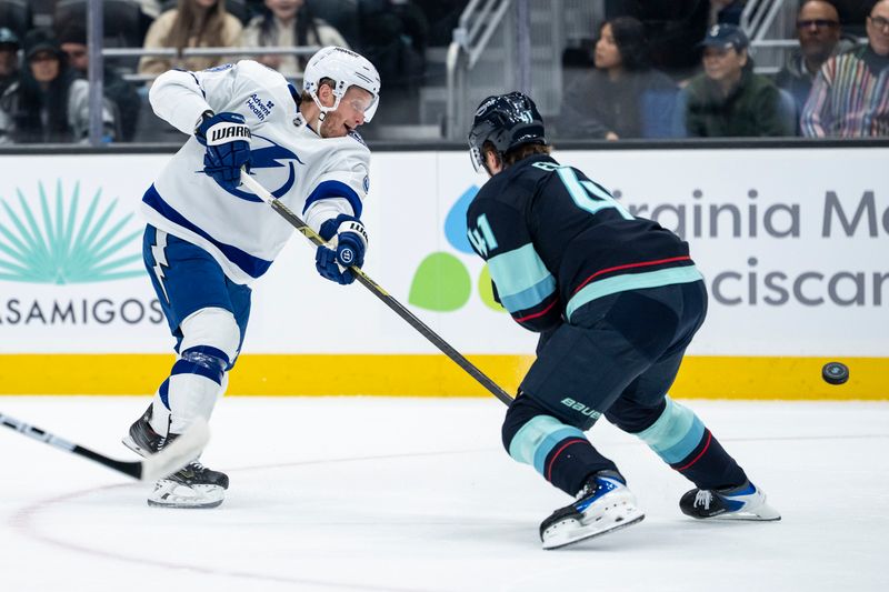 Mar 17, 2026; Seattle, Washington, USA; Tampa Bay Lightning forward Jake Guentzel (59), left, shoots the puck against Seattle Kraken defenseman Ryker Evans (41) during the first period at Climate Pledge Arena. Mandatory Credit: Stephen Brashear-Imagn Images Mar 17, 2026; Seattle, Washington, USA; Tampa Bay Lightning forward Jake Guentzel (59), left, shoots the puck against Seattle Kraken defenseman Ryker Evans (41) during the first period at Climate Pledge Arena. Mandatory Credit: Stephen Brashear-Imagn Images
