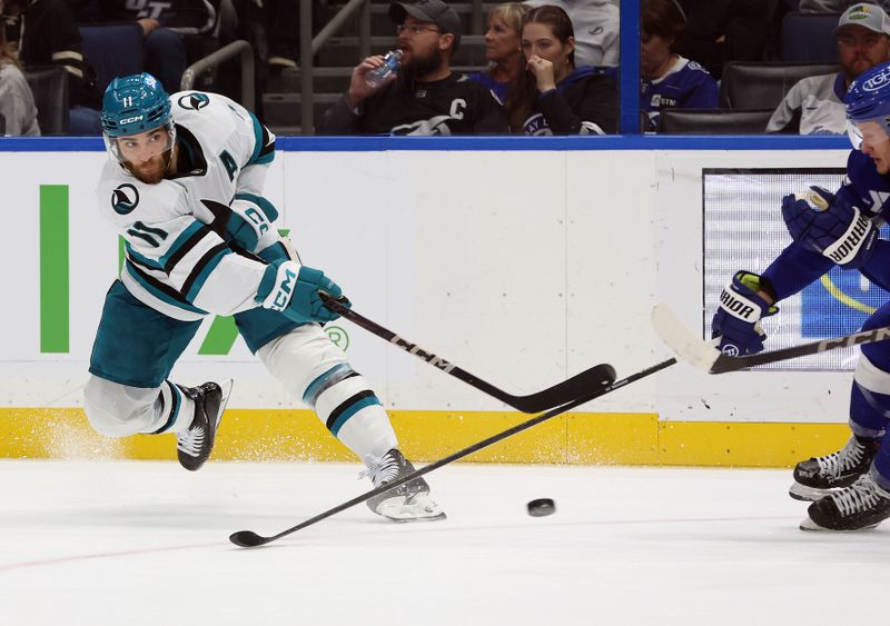 Dec 5, 2024; Tampa, Florida, USA; San Jose Sharks center Luke Kunin (11) passes the puck against the Tampa Bay Lightning during the second period at Amalie Arena. Mandatory Credit: Kim Klement Neitzel-Imagn Images