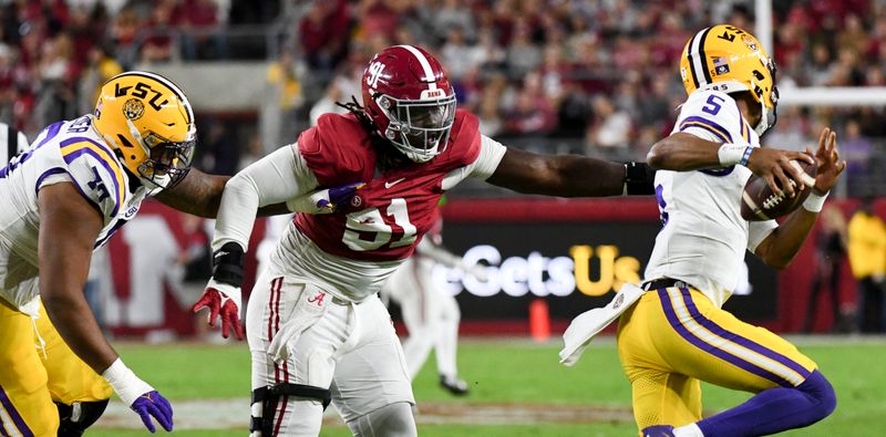 Nov 4, 2023; Tuscaloosa, Alabama, USA; LSU Tigers offensive lineman Miles Frazier (70) grabs a handful of Alabama Crimson Tide defensive lineman Jaheim Oatis (91) jersey as Oatis pressures LSU Tigers quarterback Jayden Daniels (5) at Bryant-Denny Stadium. Mandatory Credit: Gary Cosby Jr.-USA TODAY Sports