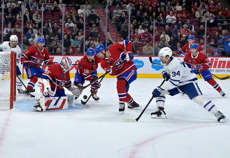 Oct 9, 2024; Montreal, Quebec, CAN; Montreal Canadiens forward Joel Armia (40) clears the puck away from teammate goalie Sam Montembeault (35) and Toronto Maple Leafs forward Auston Matthews (34) during the third period at the Bell Centre. Mandatory Credit: Eric Bolte-Imagn Images