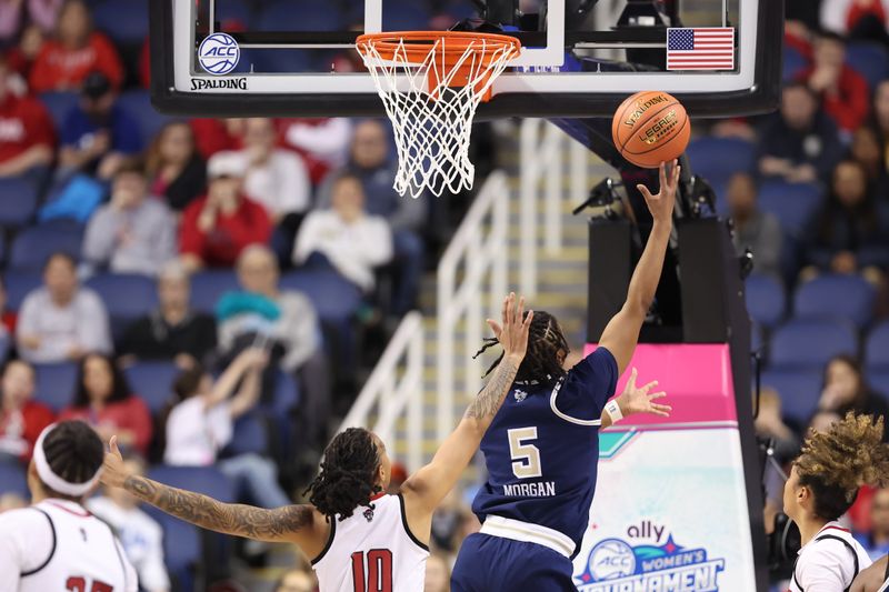 Mar 7, 2025; Greensboro, NC, USA;  Georgia Tech Yellow Jackets guard Tonie Morgan (5) shoots the ball over NC State Wolfpack guard Aziaha James (10) during the third quarter at First Horizon Coliseum. Mandatory Credit: Cory Knowlton-Imagn Images