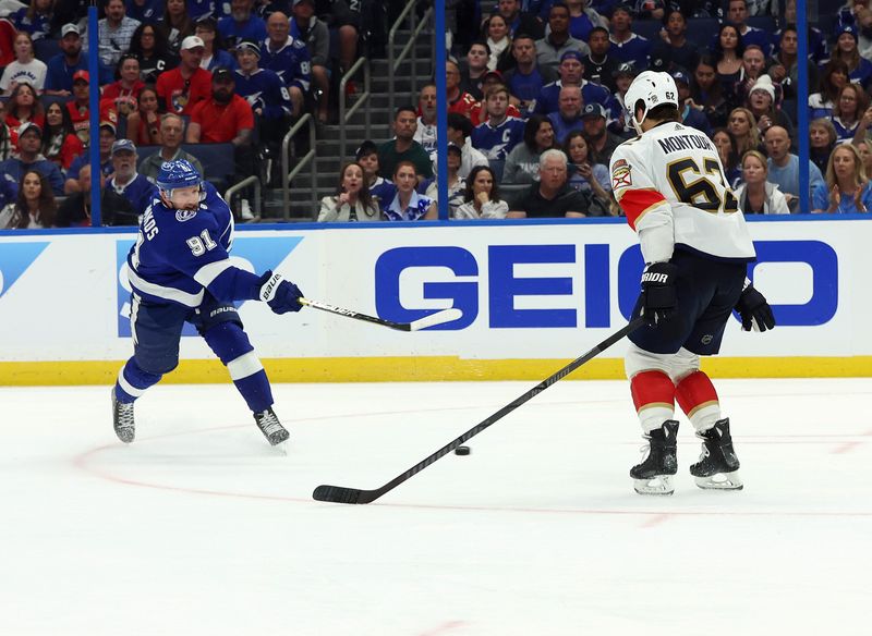 Apr 27, 2024; Tampa, Florida, USA; Tampa Bay Lightning center Steven Stamkos (91) shoots and scores a goal as Florida Panthers defenseman Brandon Montour (62) attempted to defend during the third period in game four of the first round of the 2024 Stanley Cup Playoffs at Amalie Arena. Mandatory Credit: Kim Klement Neitzel-USA TODAY Sports