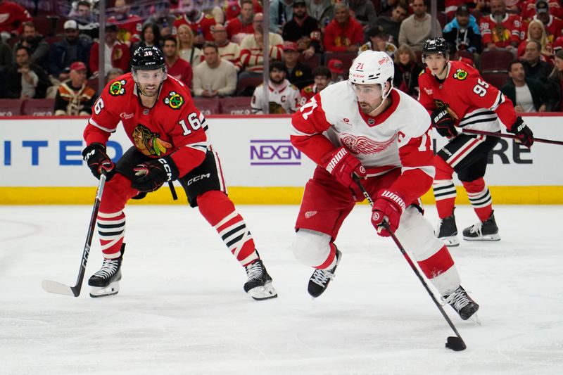 Nov 6, 2024; Chicago, Illinois, USA; Chicago Blackhawks center Jason Dickinson (16) defends Detroit Red Wings center Dylan Larkin (71) during the second period at United Center. Mandatory Credit: David Banks-Imagn Images