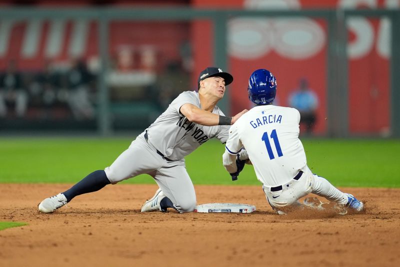 Oct 10, 2024; Kansas City, Missouri, USA; New York Yankees shortstop Anthony Volpe (11) tags out Kansas City Royals third baseman Maikel Garcia (11) at second base during the sixth inning during game four of the ALDS for the 2024 MLB Playoffs at Kauffman Stadium.Mandatory Credit: Jay Biggerstaff-Imagn Images