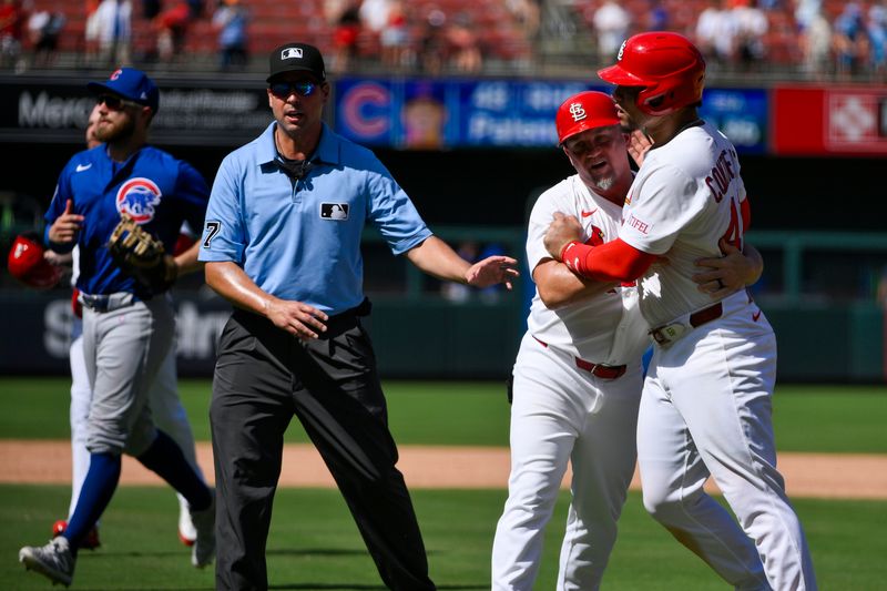 Jun 26, 2025; St. Louis, Missouri, USA;  St. Louis Cardinals first baseman Willson Contreras (40) is held back by first base coach Stubby Clapp (82) as he exchanges words with Chicago Cubs relief pitcher Daniel Palencia (not pictured) after the Cubs defeated the Cardinals at Busch Stadium. Mandatory Credit: Jeff Curry-Imagn Images