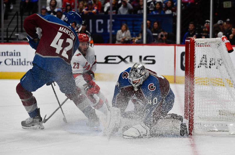 Oct 21, 2023; Denver, Colorado, USA; Colorado Avalanche goaltender Alexandar Georgiev (40) gets sprayed with ice by Colorado Avalanche defenseman Josh Manson (42) and Carolina Hurricanes right wing Stefan Noesen (23) after covering up the puck in the first period at Ball Arena. Mandatory Credit: John Leyba-USA TODAY Sports