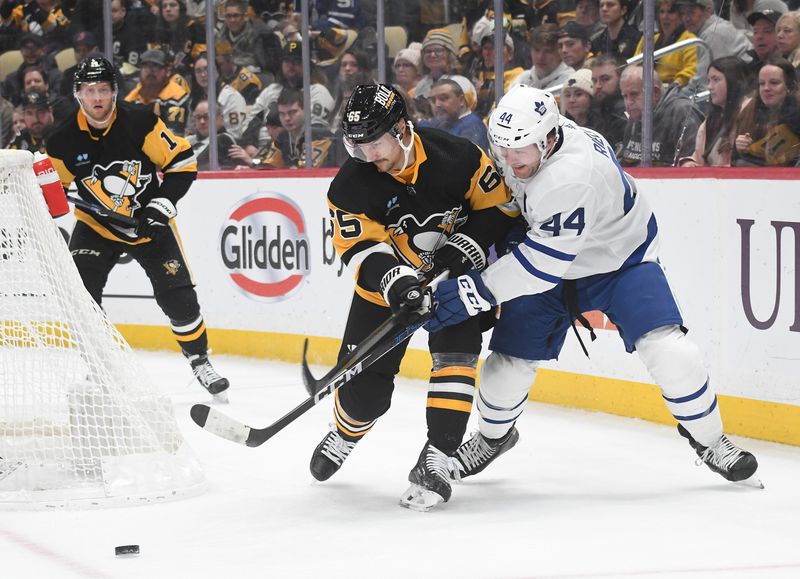 Nov 25, 2023; Pittsburgh, Pennsylvania, USA; Pittsburgh Penguins defenseman Erik Karlsson (65) and Toronto Maple Leafs  defenseman Morgan Rielly (44) go for the puck during the second period at PPG Paints Arena. Mandatory Credit: Philip G. Pavely-USA TODAY Sports