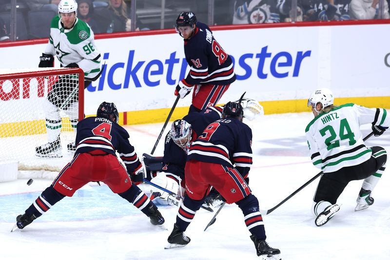 Dec 9, 2025; Winnipeg, Manitoba, CAN; Dallas Stars center Roope Hintz (24) scores on Winnipeg Jets goaltender Eric Comrie (1) in the second period at Canada Life Centre. Mandatory Credit: James Carey Lauder-Imagn Images