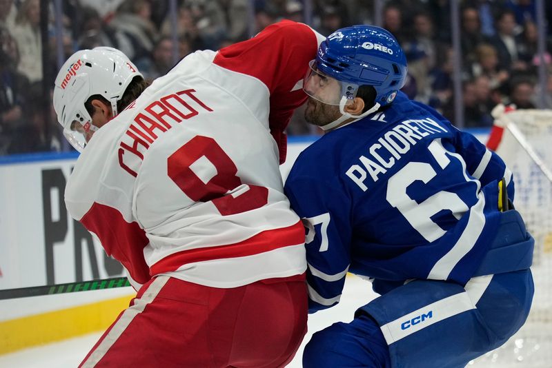 Nov 8, 2024; Toronto, Ontario, CAN; Toronto Maple Leafs forward Max Pacioretty (67) gets elbowed by Detroit Red Wings defenseman Ben Chiarot (8) as they battle for the puck during the third period at Scotiabank Arena. Mandatory Credit: John E. Sokolowski-Imagn Images