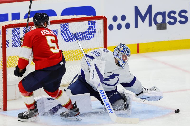 Apr 23, 2024; Sunrise, Florida, USA; Tampa Bay Lightning goaltender Andrei Vasilevskiy (88) makes a save after a shot by Florida Panthers defenseman Aaron Ekblad (5) during the third period in game two of the first round of the 2024 Stanley Cup Playoffs at Amerant Bank Arena. Mandatory Credit: Sam Navarro-USA TODAY Sports