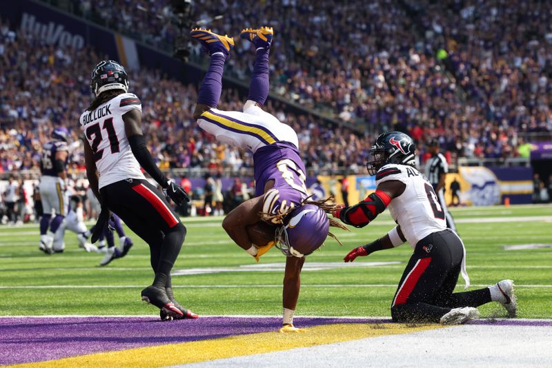 Minnesota Vikings running back Aaron Jones (33) lands in the end zone for a touchdown against the Houston Texans during the first half of an NFL football game Sunday, Sept. 22, 2024 in Minneapolis. (AP Photo/Stacy Bengs)
