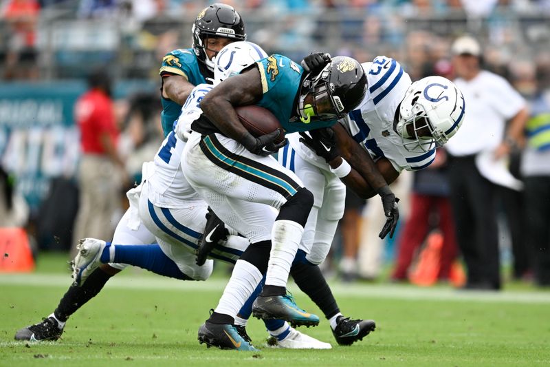 Jacksonville Jaguars running back Tank Bigsby (4) is tackled by Indianapolis Colts' Zaire Franklin (44) and Samuel Womack III (33) during the first half of an NFL football game, Sunday, Oct. 6, 2024, in Jacksonville, Fla. (AP Photo/Phelan M. Ebenhack)