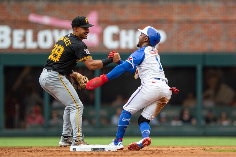 Jun 29, 2024; Cumberland, Georgia, USA; Pittsburgh Pirates second base Nick Gonzales (39) helps up Atlanta Braves second base Ozzie Albies (1) after making the out at second during the first inning at Truist Park. Mandatory Credit: Jordan Godfree-USA TODAY Sports