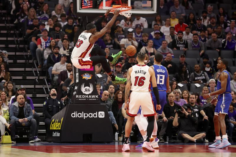 SACRAMENTO, CALIFORNIA - FEBRUARY 26: Bam Adebayo #13 of the Miami Heat dunks the ball on Keegan Murray #13 of the Sacramento Kings in the first half at Golden 1 Center on February 26, 2024 in Sacramento, California. NOTE TO USER: User expressly acknowledges and agrees that, by downloading and or using this photograph, User is consenting to the terms and conditions of the Getty Images License Agreement.  (Photo by Ezra Shaw/Getty Images)