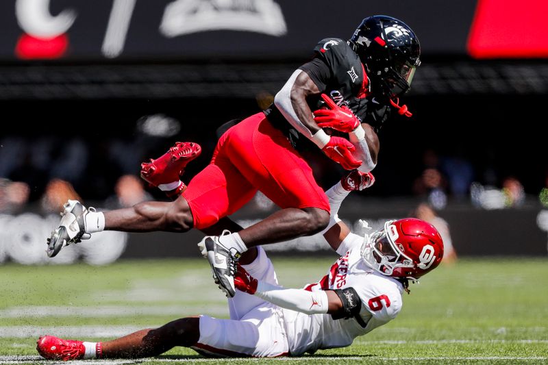 Sep 23, 2023; Cincinnati, Ohio, USA; Cincinnati Bearcats running back Myles Montgomery (26) runs with the ball against Oklahoma Sooners defensive back Makari Vickers (6) in the first half at Nippert Stadium. Mandatory Credit: Katie Stratman-USA TODAY Sports