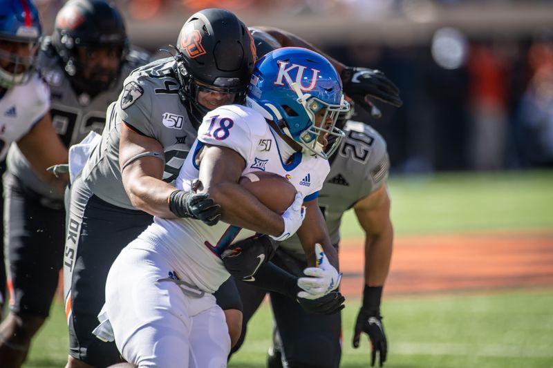 Nov 16, 2019; Stillwater, OK, USA; Kansas Jayhawks running back Velton Gardner (18) runs the ball while defended by Oklahoma State Cowboys defensive end Trace Ford (94) during the first half at Boone Pickens Stadium. Mandatory Credit: Rob Ferguson-USA TODAY Sports