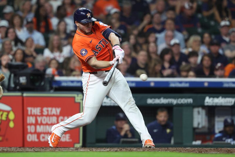 May 30, 2025; Houston, Texas, USA; Houston Astros catcher Yainer Diaz (21) hits a single during the seventh inning against the Tampa Bay Rays at Daikin Park. Mandatory Credit: Troy Taormina-Imagn Images